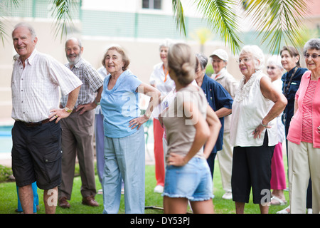 Grande gruppo di anziani che esercitano in pensione villa giardino Foto Stock