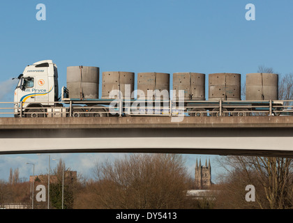 Grandi prefabbricati di calcestruzzo le sezioni di tubo di essere trasportati su strada nelle Midlands. Foto Stock