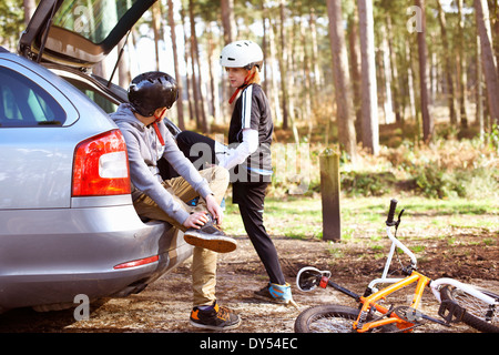 I fratelli gemelli Preparazione alla corsa biciclette BMX in foresta Foto Stock