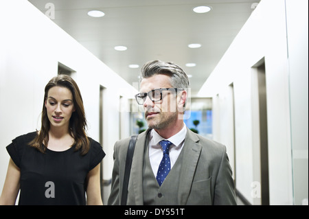 Colleghi di lavoro a camminare lungo il corridoio di office Foto Stock