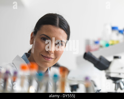 Ricercatore femmina in laboratorio accanto a microscopi. Foto Stock