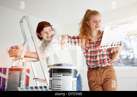 Due sorelle adolescenti preparando per decorare la camera da letto Foto Stock