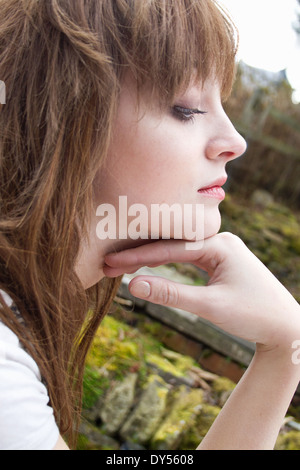 Profilo Ritratto di giovane donna con mento a portata di mano Foto Stock