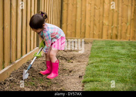 Ragazza giovane scavando nel giardino Foto Stock