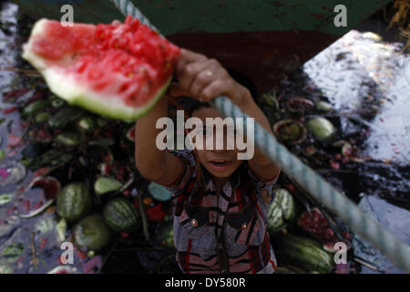 Dacca in Bangladesh. 7 apr, 2014. Un ragazzo di strada ricerca mangiabile cocomeri dal inquinato e sporco fiume Buriganga. Produzione di paraurti di anguria in Bangladesh in questa stagione. Gli esperti hanno detto che la buona qualità i cocomeri erano un raccolto abbondante di quest'anno grazie a favorire meteo e miglioramento della qualità agricola. © Zakir Hossain Chowdhury/NurPhoto/ZUMAPRESS.com/Alamy Live News Foto Stock