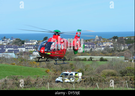 Il Galles Air Ambulance frequentando una RTA a Amlwch Anglesey North Wales UK battenti G-Wass welsh aereo elicottero Foto Stock