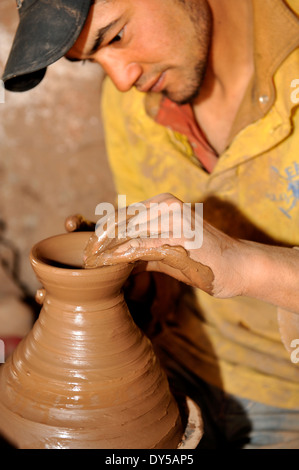 Artigiano potter gettando, rendendo, un vaso utilizzando un kick ruota in Marocco vicino a Ansi, colline ai piedi delle montagne Atlas. Dettaglio le mani. Foto Stock