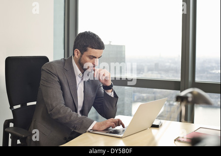 Imprenditore lavorando sul computer portatile in ufficio Foto Stock