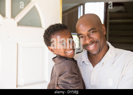 Ritratto di uomo maturo e figlio davanti alla porta di casa Foto Stock