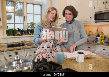 Donna Senior e nipote controllo ricetta su tavoletta digitale Foto Stock