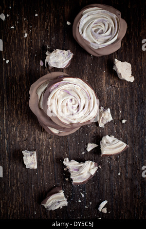 Close up di cioccolato immerso mirtillo meringa rose Foto Stock