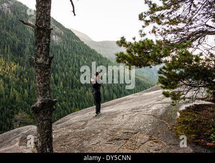 Giovane donna guardando smartphone, Squamish, British Columbia, Canada Foto Stock