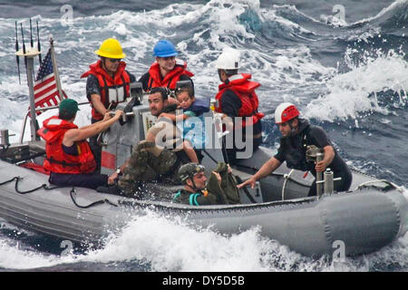 US Navy marinai da Oliver Hazard Perry-class guidato-missile fregata USS Vandegrift salvataggio di una famiglia con un bambino malato dalla loro barca a vela il cuore dei ribelli durante il salvataggio in mare Aprile 6, 2014 al largo delle coste del Messico. Foto Stock