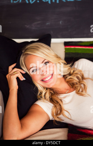 Giovane donna con capelli biondi, sorridente Foto Stock
