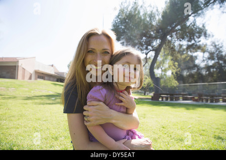 La madre abbraccia la figlia in posizione di parcheggio Foto Stock