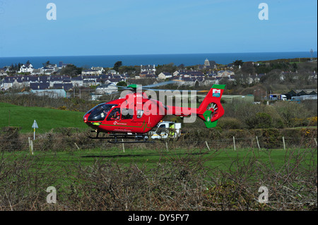 Il Galles Air Ambulance frequentando una RTA a Amlwch Anglesey North Wales UK battenti G-Wass welsh aereo elicottero Foto Stock