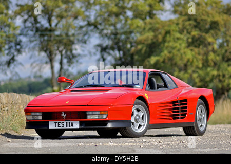 La Ferrari Testarossa in piedi su un vicolo del paese in estate con alberi in background Foto Stock