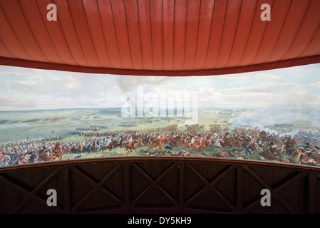 WATERLOO, Belgio — WATERLOO, Belgio — il Panorama della Battaglia di Waterloo, costruito nel 1912 per le celebrazioni centenarie della battaglia e situato accanto alla Butte du Lion (tumulo del Leone) sul campo di battaglia precedente. Il dipinto sul muro è lungo 100 metri e alto 12 metri, dipinto da Louis Dumoulin, e un team di artisti militari. Raffigura il campo di battaglia intorno alle 6 del 18 giugno 1815. Lo storico campo di battaglia di Waterloo, dove Napoleone Bonaparte affrontò la sua sconfitta finale, attira appassionati di storia e turisti, cercando di esplorare il suo ricco passato e monumenti. Foto Stock