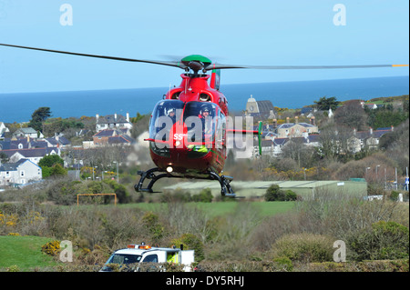 Il Galles Air Ambulance frequentando una RTA a Amlwch Anglesey North Wales UK battenti G-Wass welsh aereo elicottero Foto Stock