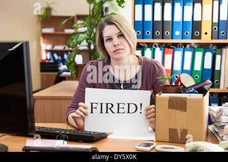 Triste donna con raccolte di cose e di un foglio di carta con la parola 'sparato' Foto Stock