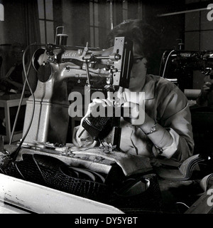 1950s, storica, una lavoratrice che utilizza una macchina da cucire Singer industriale per cucire o cucire una scarpa in pelle presso la Glenfield Progress Co-operated Society Limited, un'azienda di scarpe e stivali a Glenfield, Leicester, Inghilterra, Regno Unito. L'azienda si è specializzata in calzature per donne e bambini. Storicamente Leicestershire era un'area importante della Gran Bretagna per la produzione di calzature e nel 1872 la Co-operativaWholesale Society iniziò a fabbricare scarpe lì. Inventato da Isaac Singer negli anni '1820s, originariamente per la cucitura di tessuti, produsse negli anni '1840s una versione abbastanza robusta per la pelle. Foto Stock