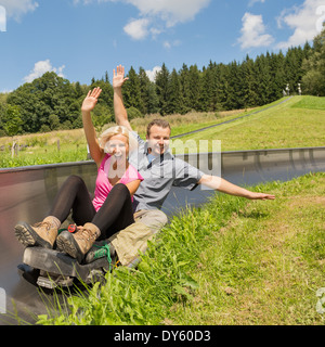 Ritratto di giovane coppia godendo estate giro in slitta Foto Stock