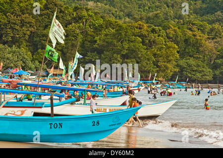 Outrigger barche di pescatori sulla spiaggia occidentale dell'istmo a questo grande beach resort sulla costa sud, Pangandaran, Java, Indonesia Foto Stock