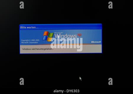 Schwerin, Germania. 08 apr 2014. Illustrazione - un'immagine illustrata mostra la notifica " Windows è in fase di arresto' sotto il logo del sistema operativo del computer Windows XP sullo schermo di un computer a Schwerin, Germania, 08 aprile 2014. Microsoft Corporation si fermerà il sostegno del suo sistema operativo Windows XP con gli aggiornamenti necessari per il 08 aprile 2014. Foto: Jens Buettner/dpa/Alamy Live News Foto Stock