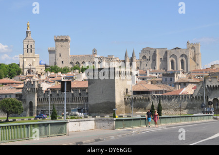 Due persone attraversando il Pont Edouard Daladier, con il Palais des Papes in background, Avignone Foto Stock