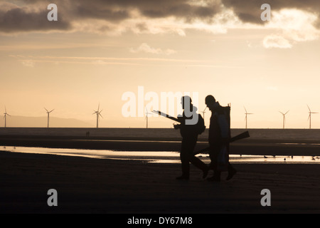 Due stagliano i pescatori di mare sulla spiaggia di Formby punto, Liverpool Bay con uno sfondo di La Banca Burbo offshore wind farm. Foto Stock