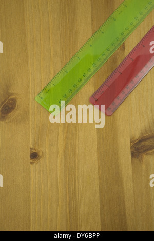 Vista in elevazione di un rosso e verde righello su un tavolo di legno Foto Stock