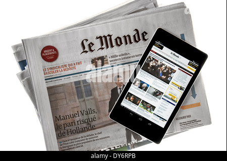 Touchscreen tavoletta digitale che mostra online world news sulla sommità del francese Le Monde giornale su sfondo bianco Foto Stock