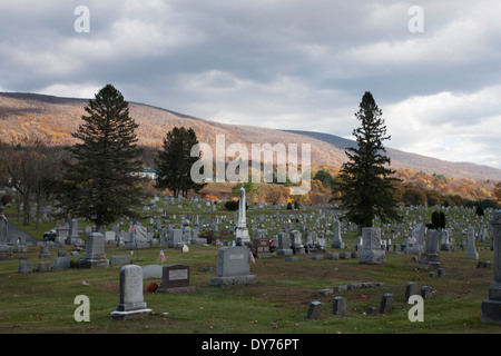 In un cimitero di North Adams Massachusetts con il sole al tramonto sulle montagne. Foto Stock