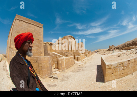 African American uomo ( età 62 ) indossando turbante rosso permanente al tempio di Saqqara in Egitto. Foto Stock