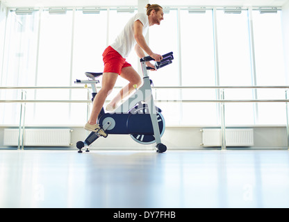 Ritratto di giovane uomo della formazione su speciali attrezzature sportive in palestra Foto Stock