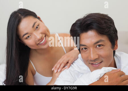 Coppia felice giacente sul letto insieme Foto Stock