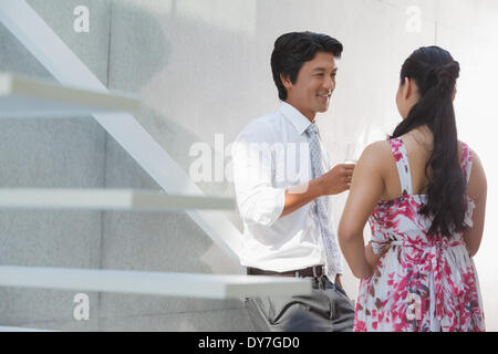 Uomo che parla con la sua ragazza che indossa un abito floreale Foto Stock