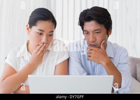 Preoccupato per il giovane utilizzando laptop insieme Foto Stock