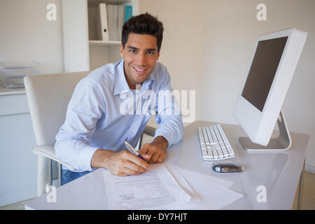 Imprenditore informale seduti alla scrivania la scrittura Foto Stock