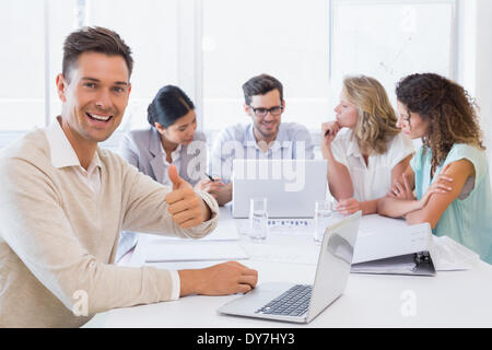 Business Casual squadra di avere un incontro con l'uomo dando pollice in alto Foto Stock