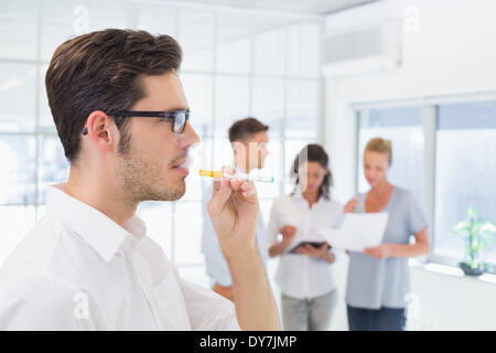 Casual uomo d affari di fumare una sigaretta elettronica Foto Stock