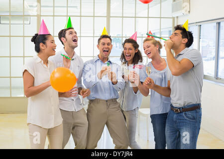 Casual business team festeggia con champagne e party poppers Foto Stock