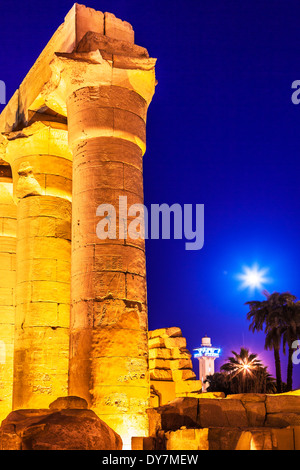 Antiche colonne egiziane al Tempio di Luxor con una moschea moderna in background. Foto Stock