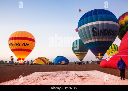 I palloni ad aria calda nelle varie fasi di predisposizione per il decollo di un volo di sunrise dalla Riva a Ovest del Nilo in Egitto. Foto Stock