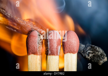 Partite vengano accesi che mostra le fiamme in corrispondenza del punto di contatto, su uno sfondo nero. La masterizzazione di partite dopo che viene acceso. Foto Stock