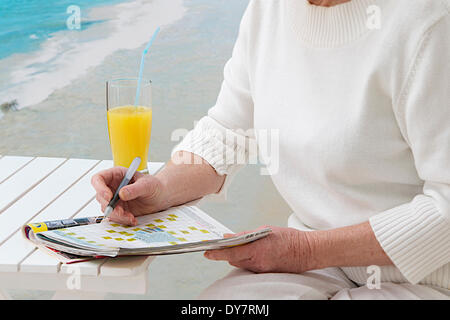 Persona anziana facendo cr-parola puzzle Foto Stock