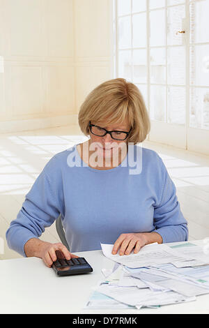 Persona anziana e facendo di documenti cartacei Foto Stock
