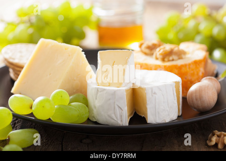 Vari tipi di formaggio con uva, miele e noci Foto Stock