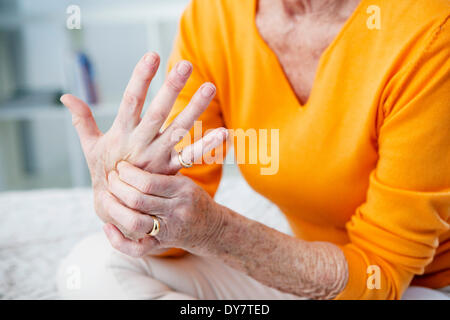 Persona anziana con mano dolorosa Foto Stock