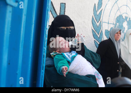 La striscia di Gaza, Territori palestinesi. 9 Apr 2014. Palestinesi prendere parte a una manifestazione di protesta contro la decisione presa dall'Ente soccorso e lavori delle Nazioni Unite (UNRWA) a ridurre le forniture di aiuto alimentare di fronte al quartier generale dell'UNRWA di Gaza City, il 9 aprile 2014. © Majdi Fathi/NurPhoto/ZUMAPRESS.com/Alamy Live News Foto Stock